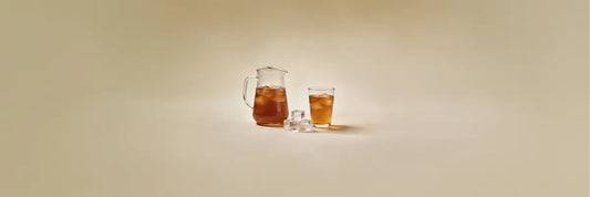 A glass of chilled mugicha barley tea with condensation on a warm day, showcasing its deep amber colour